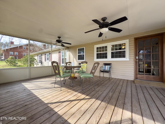 wooden terrace with a ceiling fan and outdoor dining space