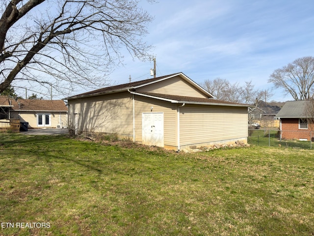 view of side of home featuring a yard, fence, and a patio area