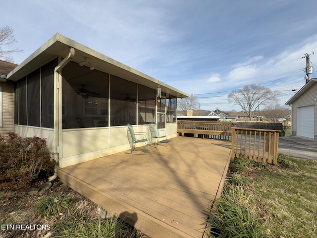 view of side of home featuring a deck, ceiling fan, and a sunroom