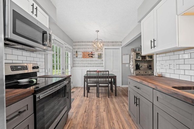 3295 Cimarron Trl, Murfreesboro, TN 37129 - kitchen featuring an inviting chandelier, decorative backsplash, butcher block countertops, light wood finished floors, and appliances with stainless steel finishes