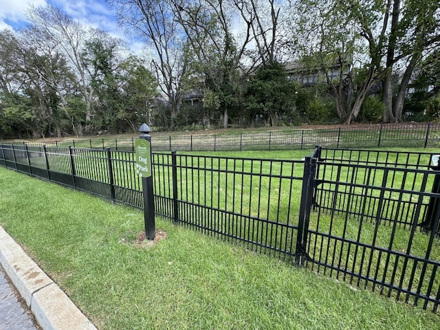 view of home's community with fence and a yard
