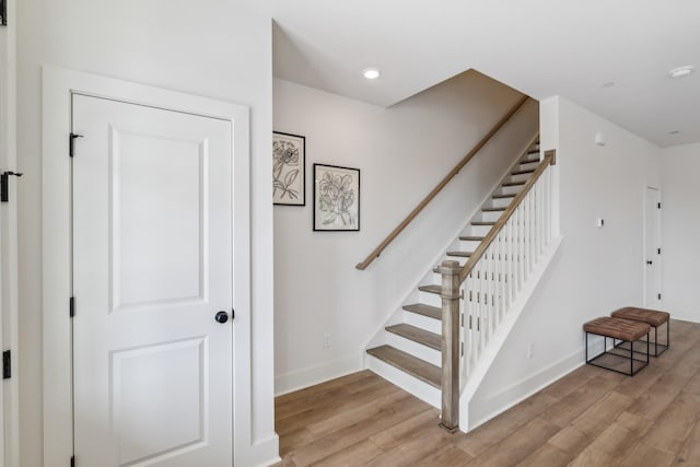 stairway featuring recessed lighting, baseboards, and wood finished floors