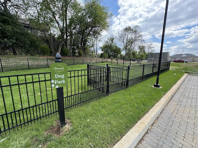 view of home's community with fence and a yard