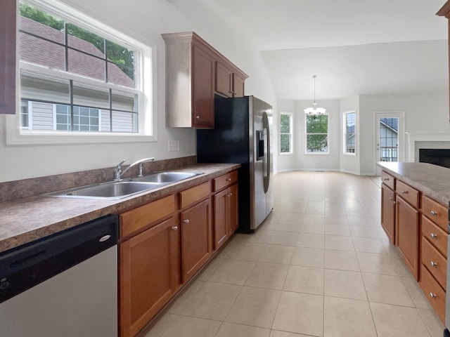 4013 Kristen St, Spring Hill, TN 37174 - kitchen featuring appliances with stainless steel finishes, vaulted ceiling, brown cabinets, a sink, and a notable chandelier