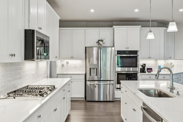 5017 Great Falls Ct, College Grove, TN 37046 - kitchen featuring appliances with stainless steel finishes, a sink, white cabinetry, hanging light fixtures, and backsplash