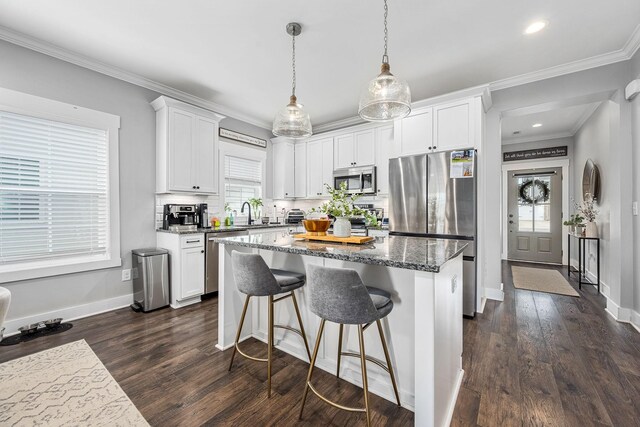 3420 Caroline Farms Dr, Murfreesboro, TN 37129 - kitchen featuring stainless steel appliances, a center island, white cabinets, crown molding, and dark stone counters