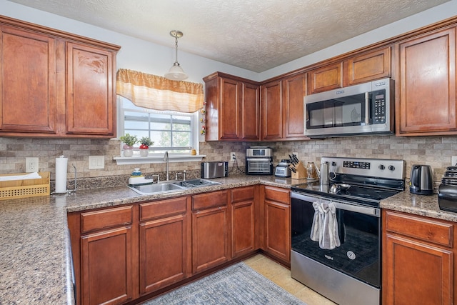 kitchen featuring decorative backsplash, brown cabinets, a sink, decorative light fixtures, and stainless steel appliances