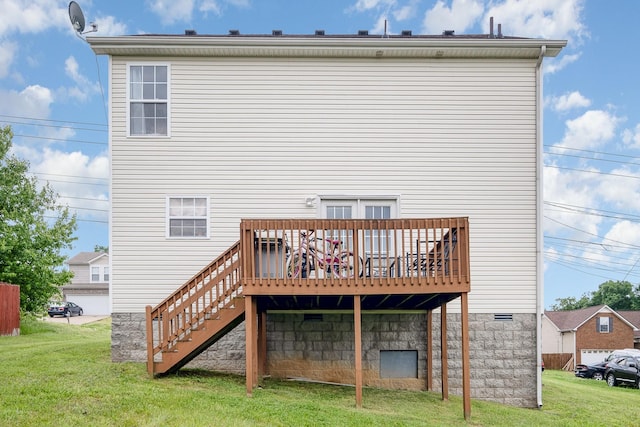 back of property featuring a lawn, a wooden deck, and stairway