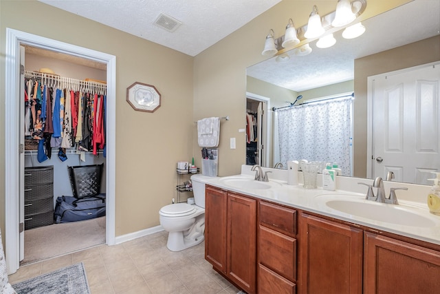 full bath featuring double vanity, toilet, visible vents, and a sink