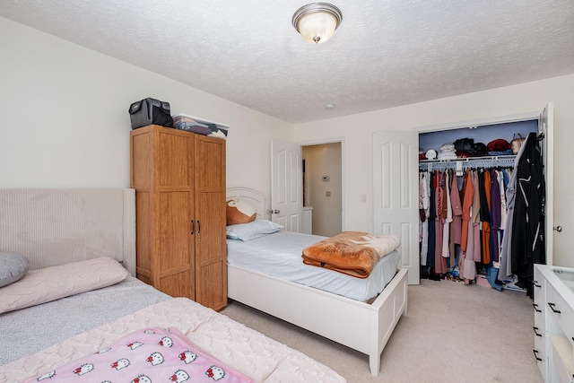 bedroom with a textured ceiling, light carpet, and a closet