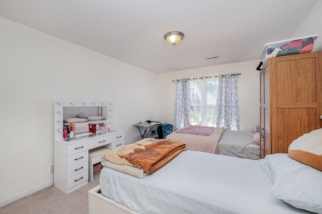 bedroom with visible vents, baseboards, and light carpet