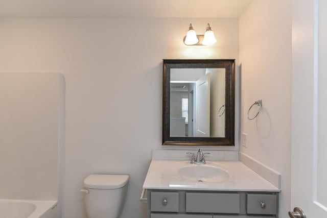 full bathroom with toilet, a tub to relax in, and vanity