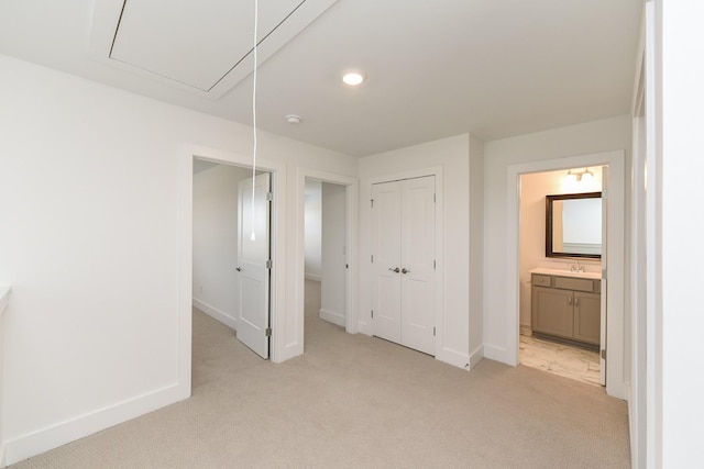 unfurnished bedroom featuring attic access, baseboards, a closet, light carpet, and recessed lighting