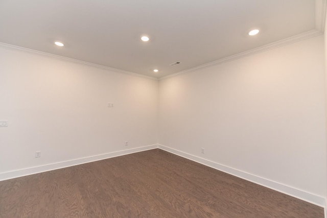 spare room featuring baseboards, ornamental molding, and dark wood finished floors