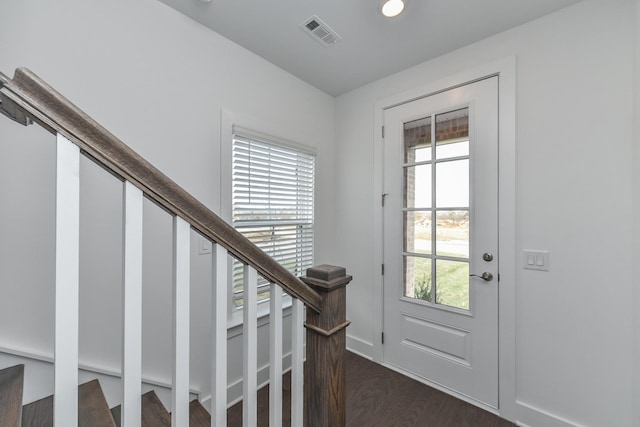 entrance foyer with visible vents, a healthy amount of sunlight, and dark wood-style floors