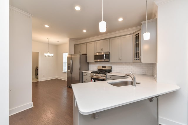kitchen featuring gray cabinets, decorative backsplash, appliances with stainless steel finishes, a sink, and baseboards