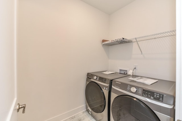 laundry room with separate washer and dryer, baseboards, and laundry area