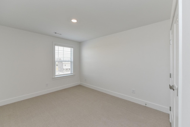 empty room with baseboards, recessed lighting, visible vents, and light carpet