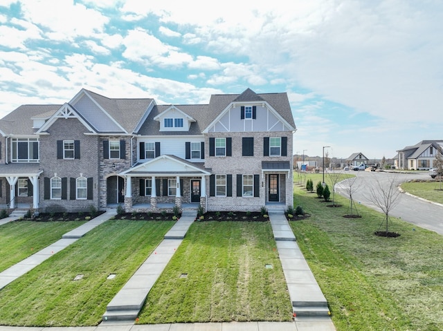 multi unit property featuring covered porch and a front yard