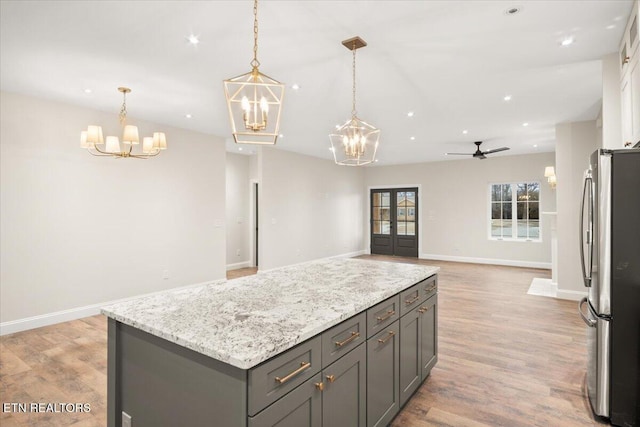 1983 Kaylee Dr, Jefferson City, TN 37760 - kitchen featuring light stone counters, light wood-style floors, freestanding refrigerator, open floor plan, and a kitchen island