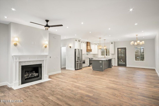 1983 Kaylee Dr, Jefferson City, TN 37760 - unfurnished living room with light wood-style floors, a fireplace, ceiling fan with notable chandelier, recessed lighting, and baseboards