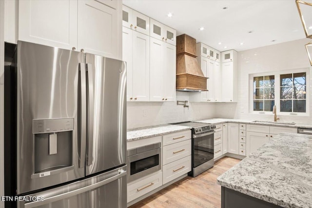 1983 Kaylee Dr, Jefferson City, TN 37760 - kitchen with white cabinets, appliances with stainless steel finishes, a sink, light wood-type flooring, and custom exhaust hood