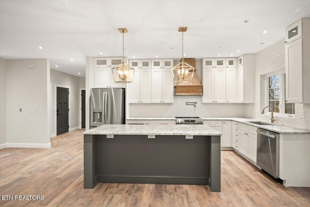 1983 Kaylee Dr, Jefferson City, TN 37760 - kitchen featuring wall chimney range hood, a center island, white cabinetry, a sink, and appliances with stainless steel finishes