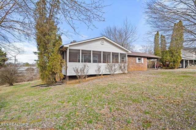 716 Lakewood Dr, Jefferson City, TN 37760 - rear view of property featuring a yard, a carport, a sunroom, and brick siding
