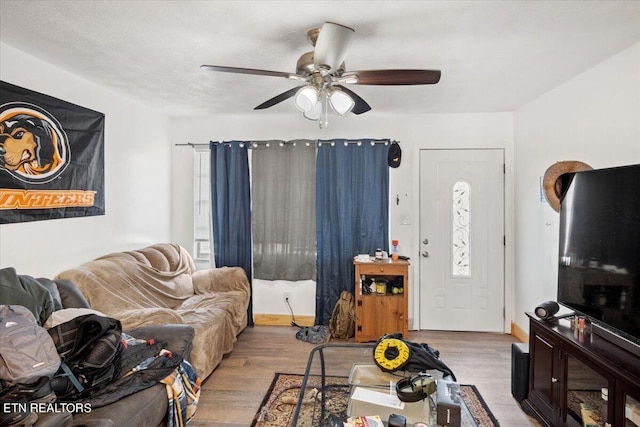 living room with a ceiling fan and wood finished floors