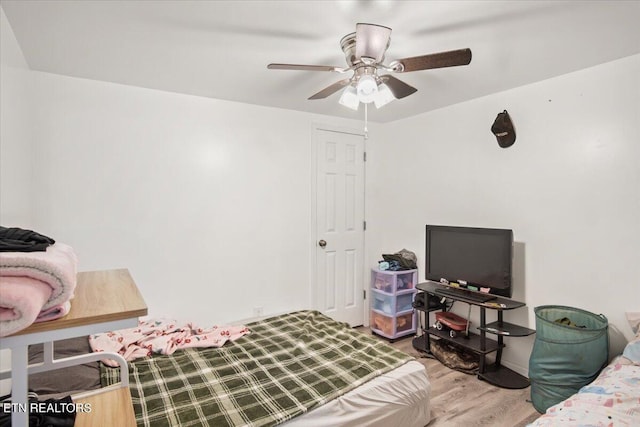 bedroom with baseboards, ceiling fan, and wood finished floors