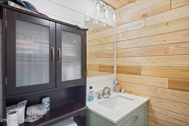 washroom with a sink and wood walls
