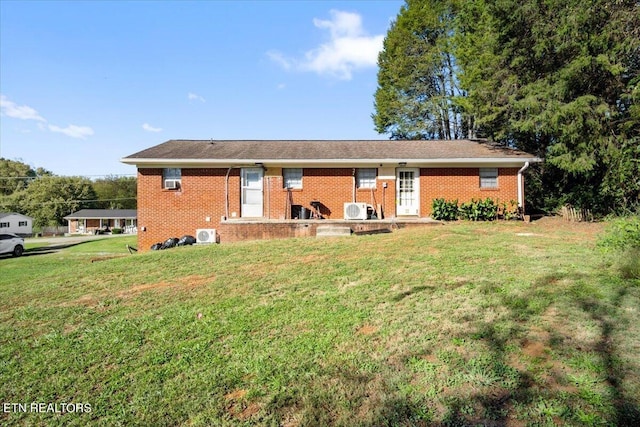 back of property with a yard and brick siding