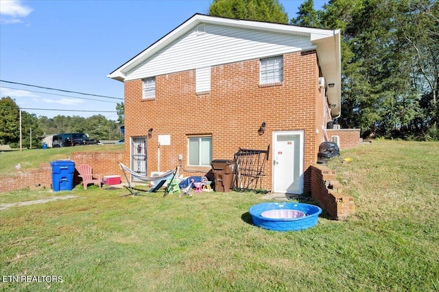 rear view of property with a yard and brick siding