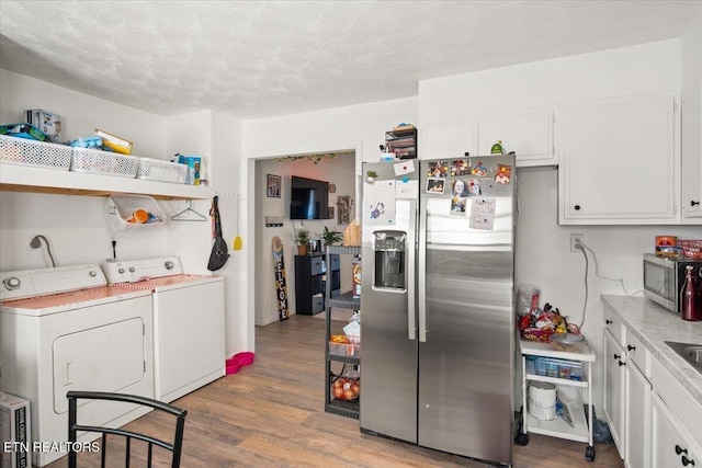 kitchen with light wood-style floors, open shelves, washer and dryer, and stainless steel appliances