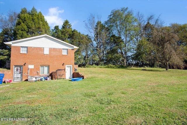 exterior space featuring brick siding and a yard