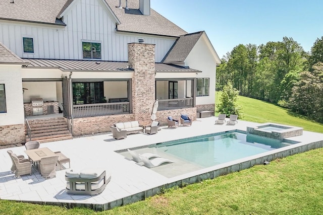 back of property with a patio, an outdoor hangout area, a standing seam roof, exterior kitchen, and a yard