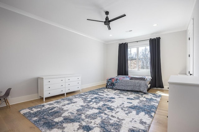 bedroom with visible vents, ornamental molding, baseboards, a ceiling fan, and light wood-style flooring