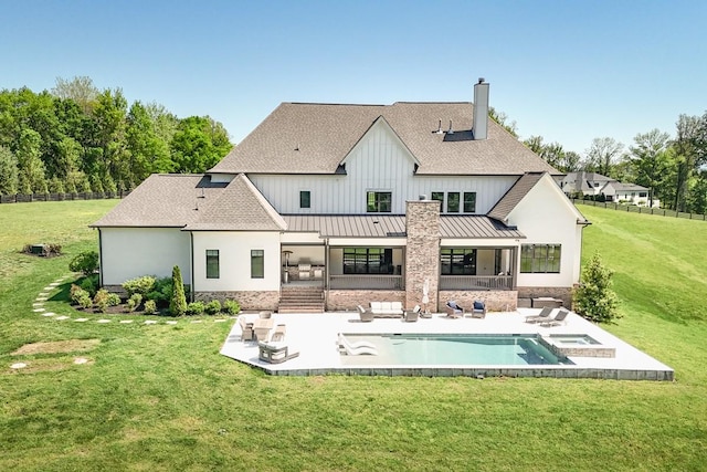 rear view of house featuring a shingled roof, a patio area, a chimney, and a standing seam roof