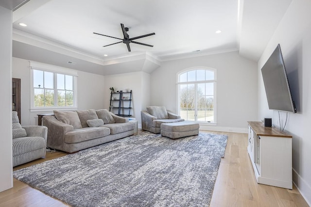 living room featuring light wood-style floors, a ceiling fan, and a healthy amount of sunlight