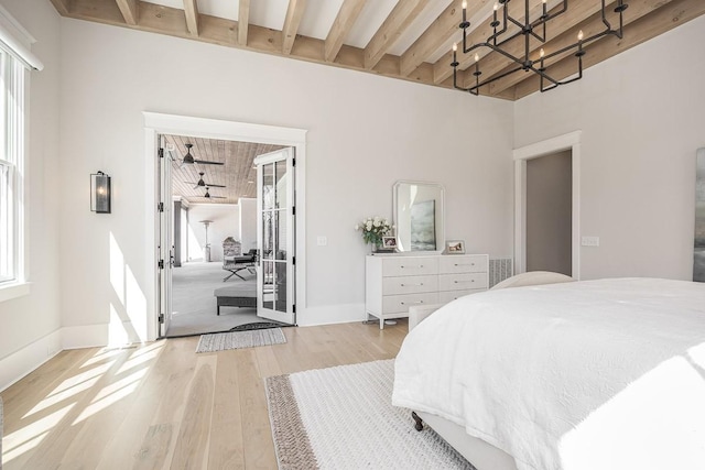 bedroom featuring baseboards, an inviting chandelier, wood finished floors, and beam ceiling