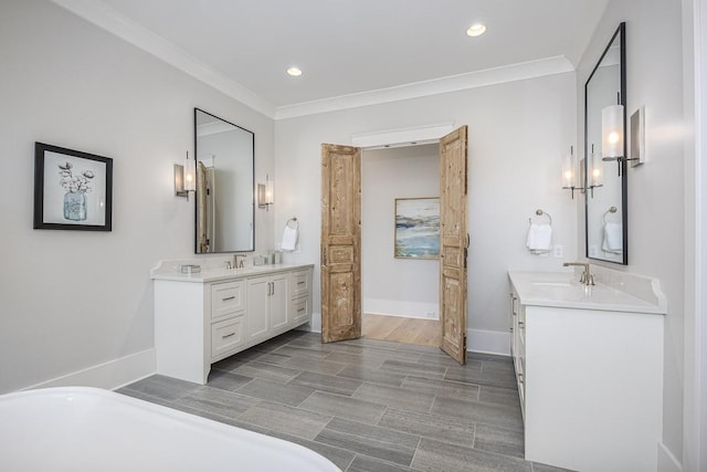 full bath with crown molding, a sink, two vanities, and a soaking tub