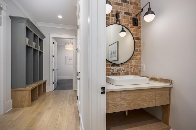 bathroom featuring vanity, baseboards, crown molding, and hardwood / wood-style floors