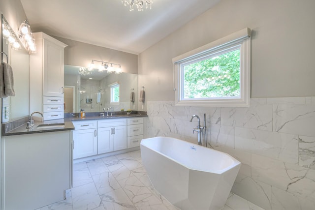 bathroom with vanity, marble finish floor, tile walls, a freestanding bath, and a stall shower