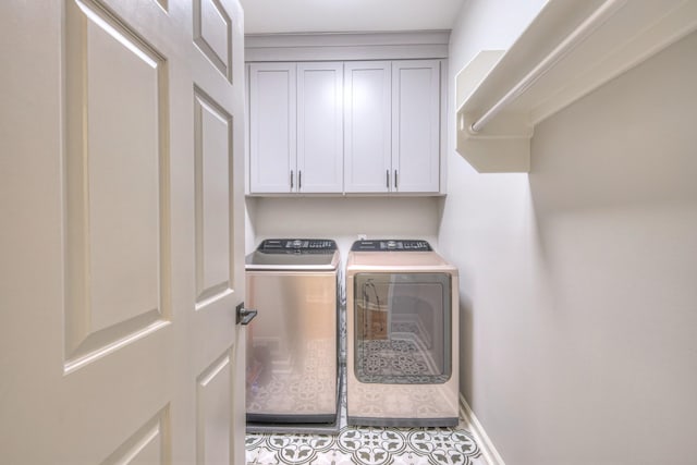 washroom with washer and clothes dryer and cabinet space