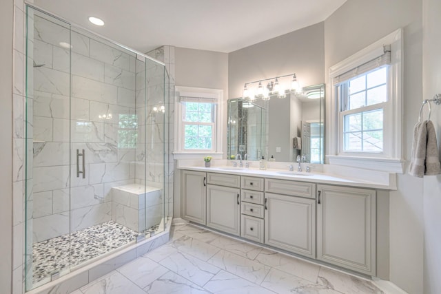 bathroom featuring a healthy amount of sunlight, a sink, marble finish floor, and a stall shower