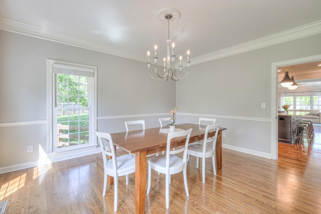 dining area featuring crown molding, visible vents, wood finished floors, baseboards, and a notable chandelier