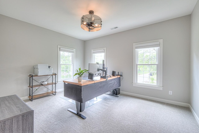 carpeted office space featuring baseboards, a healthy amount of sunlight, and visible vents