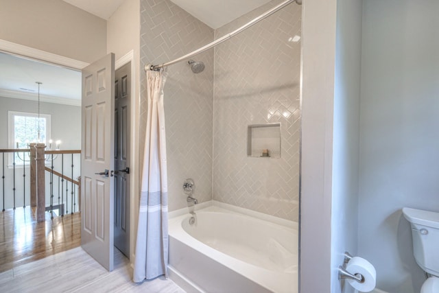 bathroom with an inviting chandelier, toilet, wood finished floors, shower / tub combo, and ornamental molding