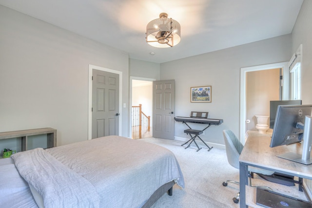 carpeted bedroom featuring baseboards and ensuite bath