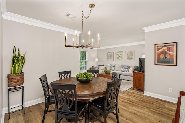 8542 Sawyer Brown Rd, Nashville, TN 37221 - dining space with visible vents, crown molding, wood finished floors, baseboards, and an inviting chandelier
